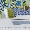 Twin bed; bunk bed divides into two full size single beds, with green chair and chest of drawers, large scale wall mural on the wall