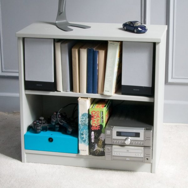 Bookcase with two adjustable shelves, filled with toys and books.