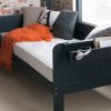 Close up detail of Little folks furniture Painswick blue sofa bed with hook on shelf and storage bookcase for kids.