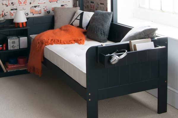 Close up detail of Little folks furniture Painswick blue sofa bed with hook on shelf and storage bookcase for kids.