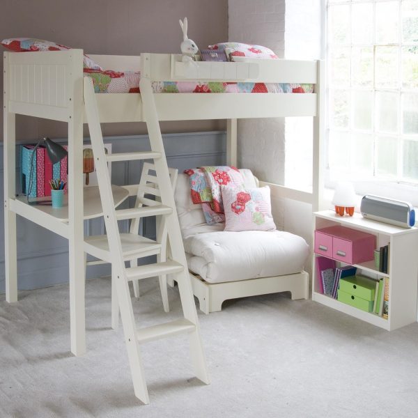 White bunk bed with corner desk and sleepover futon in a girl's bedroom, with a bookcase and large window.