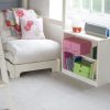 folded futon chair bed in child's room, with storage bookcase to the side.