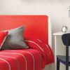 Close up of a The Edit red and white bed with curved retro edges and red bedding