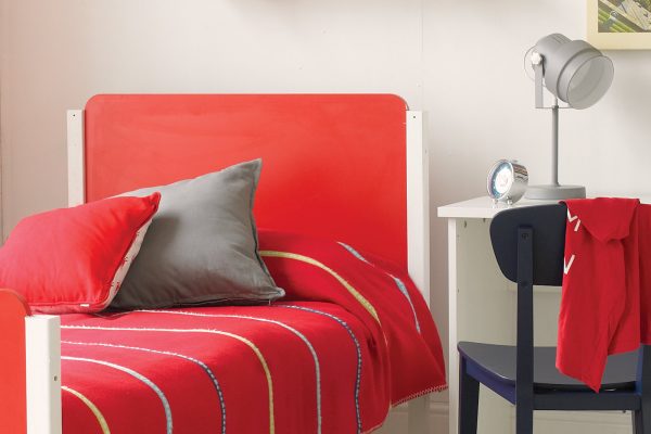 Close up of a The Edit red and white bed with curved retro edges and red bedding