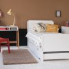 white single bed with trundle with scandi desk and red chair