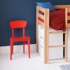 red chair, end of mid sleeper cabin bed, and a set of white drawers underneath the bed