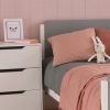 Close up Edit grey and white bed, with chest of drawers in pink room