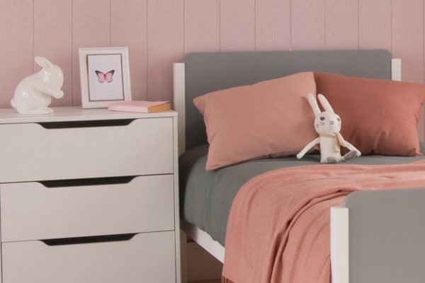 Close up Edit grey and white bed, with chest of drawers in pink room