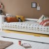 Day bed with trundle pulled out as a sleepover bed, next to a chest of drawers against a tan wall