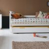 kids day bed with sleepover and storage trundle underneath, with tan coloured wall.