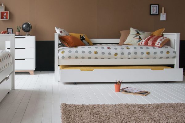 kids day bed with sleepover and storage trundle underneath, with tan coloured wall.