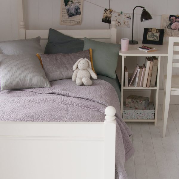 Detail of Fargo storage desk, chair and bed underneath the high sleeper bed frame, flower pictures, layers of blankets