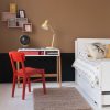 Red Retro chair for kids + scandi Edit desk, next to kid's bed with boxes on the wall