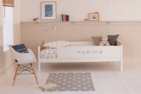 Plain white kids bunk bed with modern rounded edges, lean to ladder, and large scale tropical wall mural