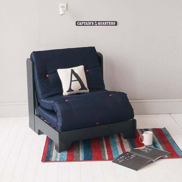 navy futon chair bed in child's blue white and red bedroom